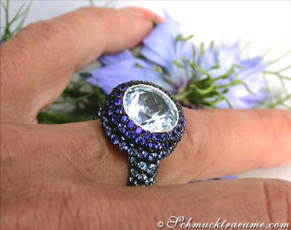 Weißgold-Ring mit blauem Blautopas und Saphiren, Detailaufnahme, blauer Hintergrund