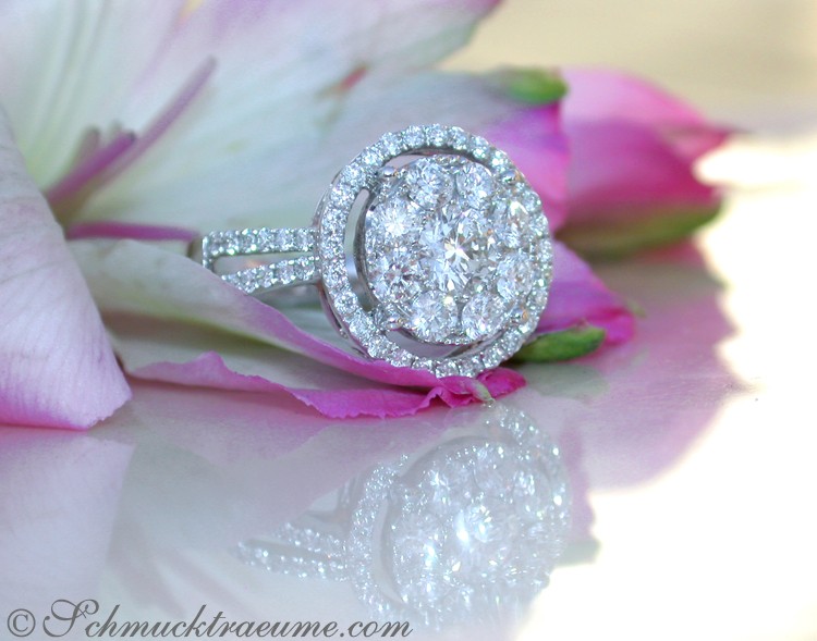 Blumiger Hintergrund, elegant erlesener Brillantenring im Halo-Design auf Blüte