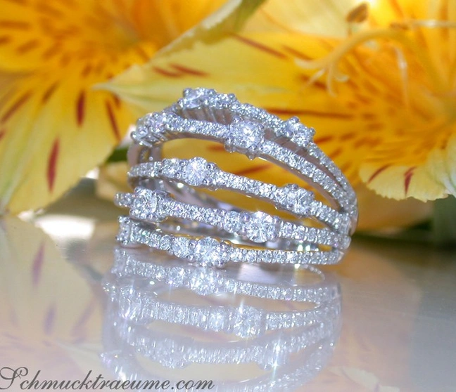 Dreireihiger Diamant-Ring in Weißgold, glitzernd, auf glänzender Oberfläche, Hintergrund mit gelber Blume. Dreireihiger Diamant-Ring in Weißgold, glitzernd, auf glänzender Oberfläche, Hintergrund mit gelber Blume.