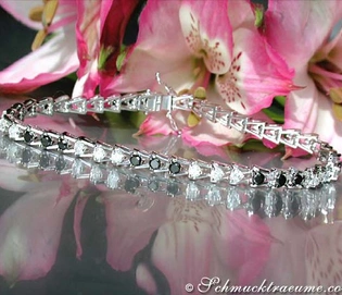 Schwarz-Weiß-Diamant-Tennisarmband auf rosa Blütenhintergrund