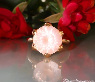 Rosenquarz-Ring in Roségold mit Blumen im Hintergrund