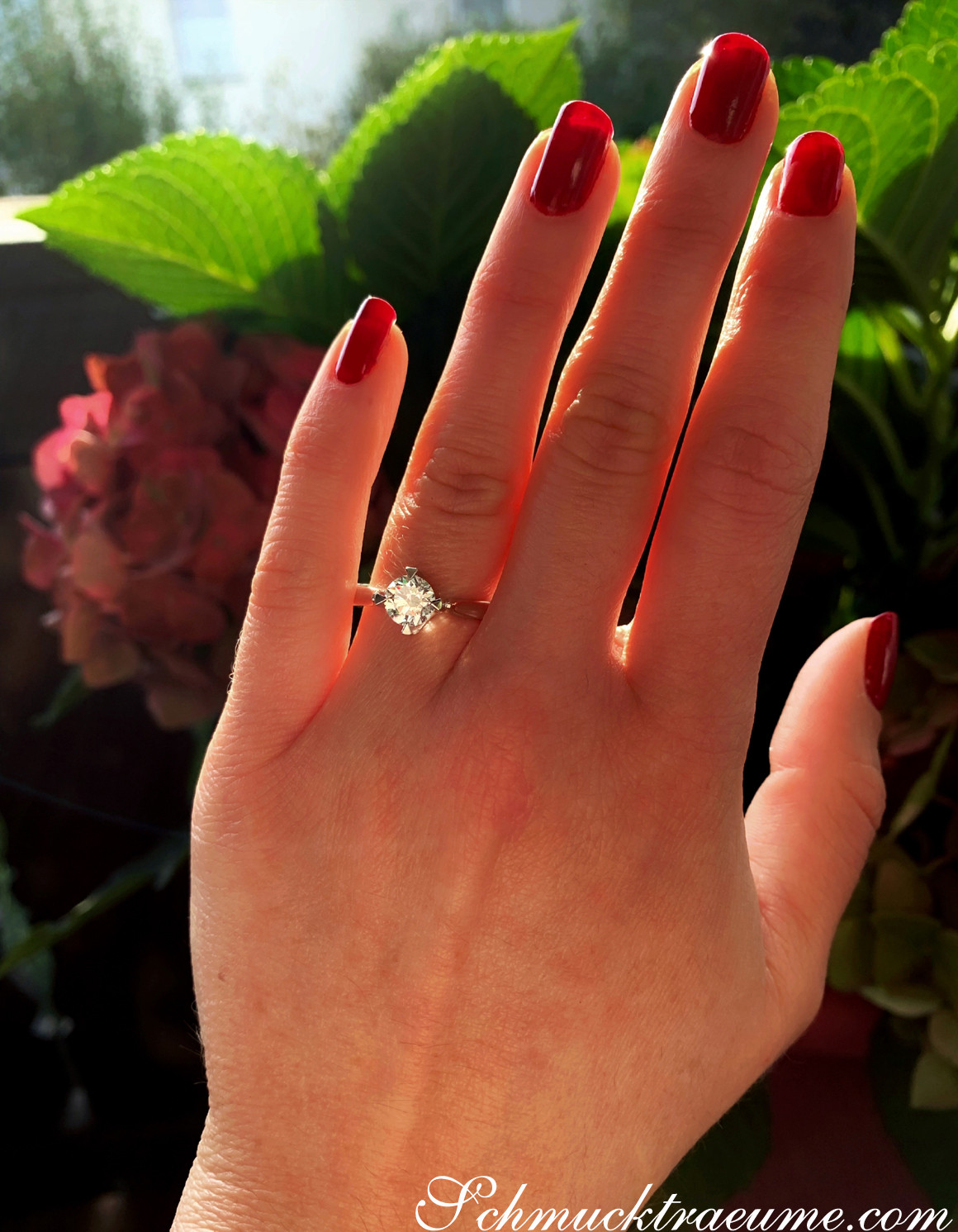 Ringschönheit mit roten Nagellack und elegantem Brillant Solitär-Ring