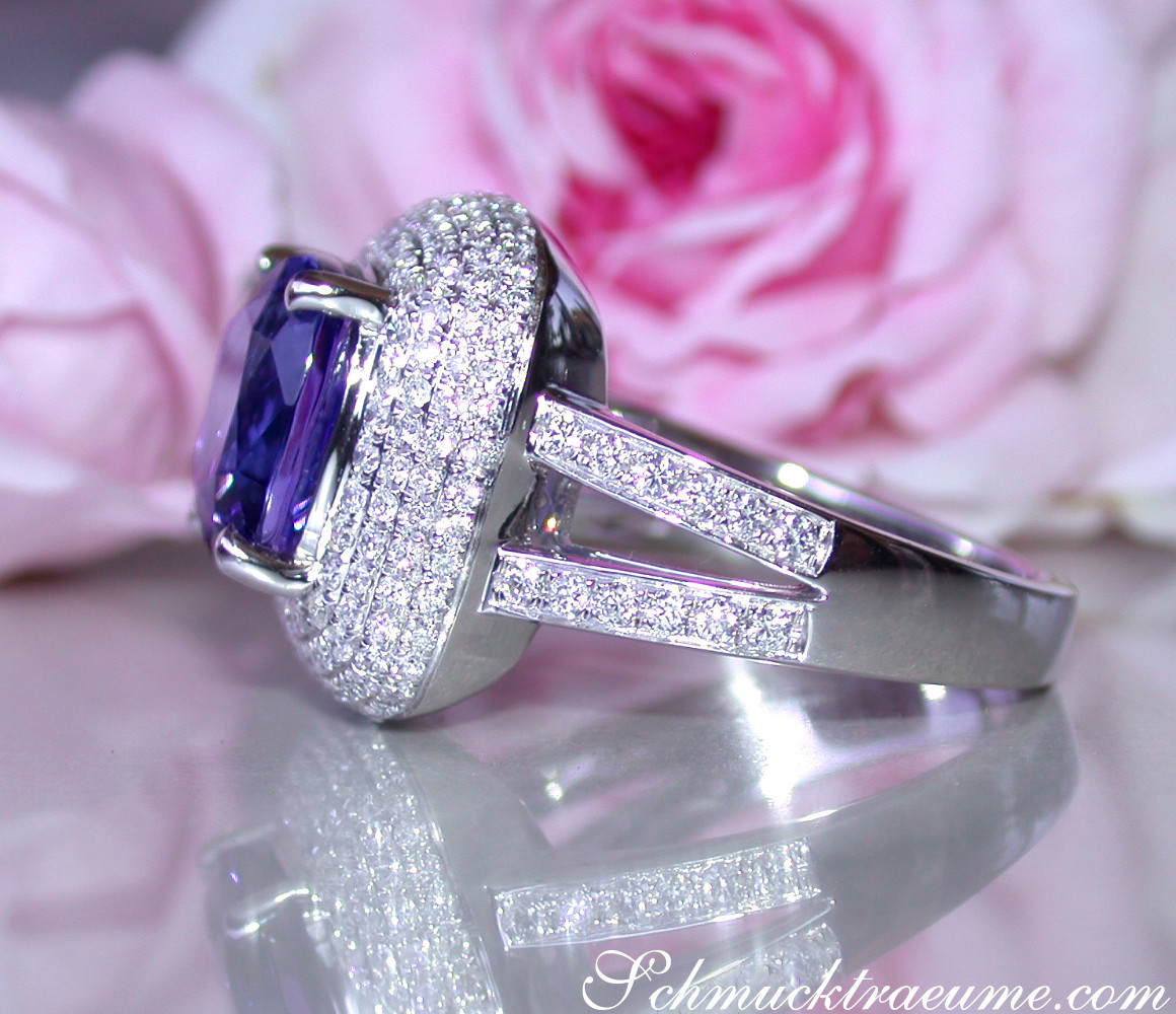 Silberner Ring mit Tansanit und Brillanten, Detailaufnahme, rosa Blume im Hintergrund