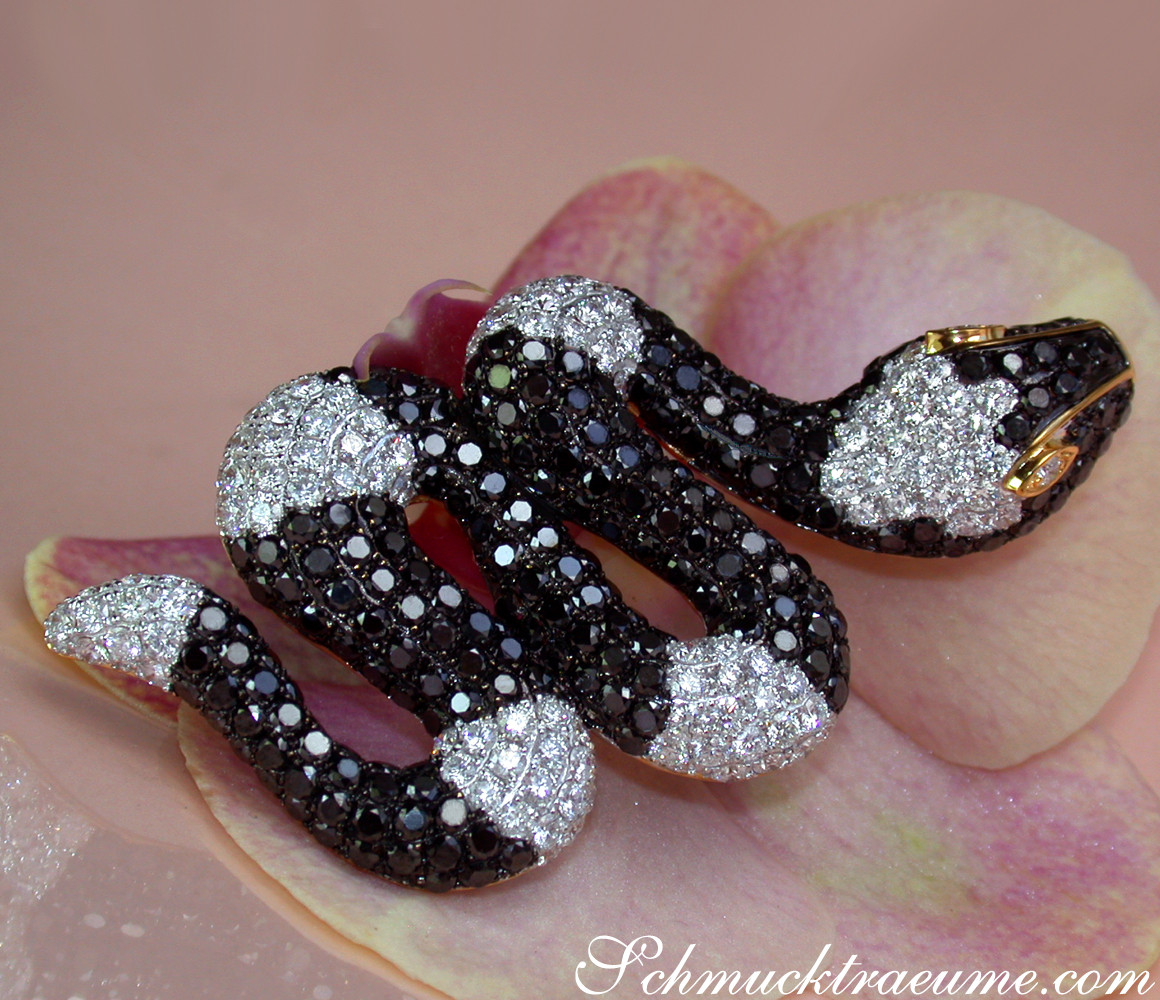 Schlangenanhänger mit schwarzen & weißen Diamanten auf Orchideenblüte.