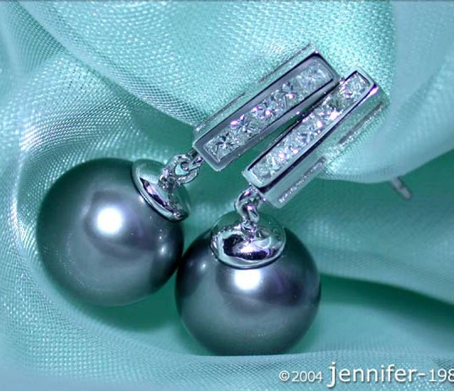 Tahitiperlen-Ohrringe mit Diamanten in Weißgold 750, Detailaufnahme auf grünem Stoff. Tahitiperlen-Ohrringe mit Diamanten in Weißgold 750, Detailaufnahme auf grünem Stoff.