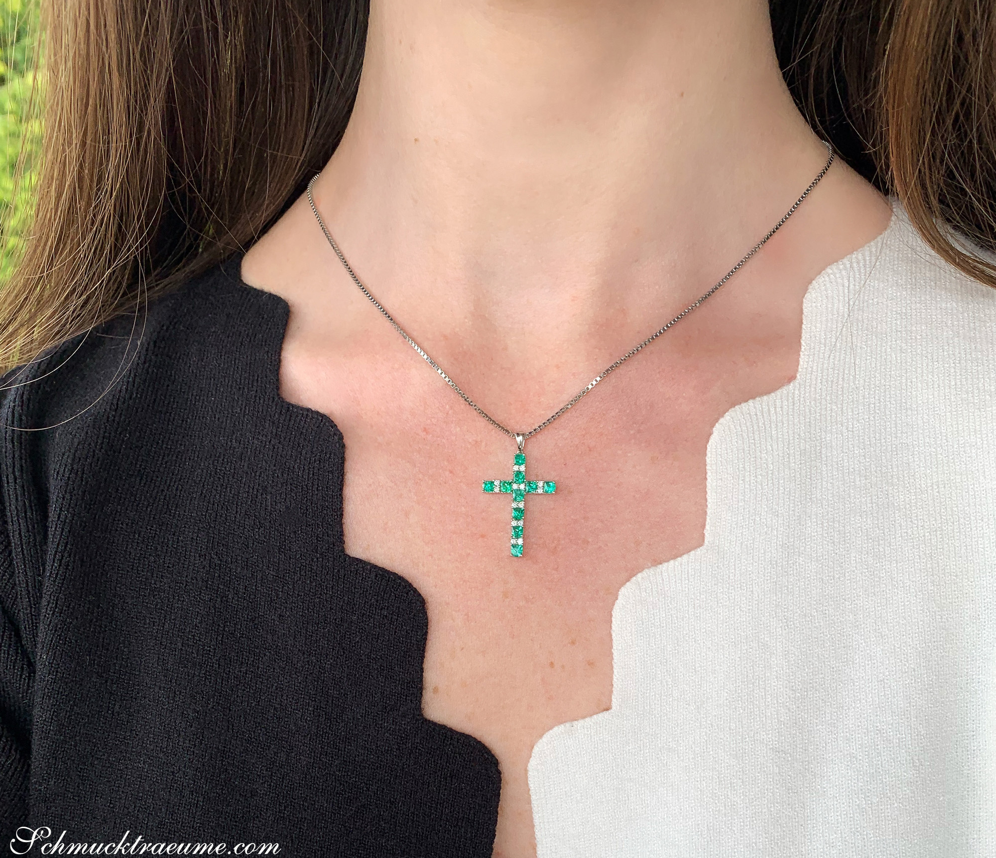 Kreuzanhänger mit Smaragden und Brillanten, detailgetreu auf Silberkette getragen