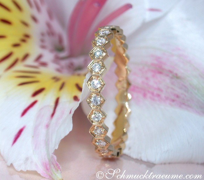Goldene Diamantring-Set mit Blume im Hintergrund