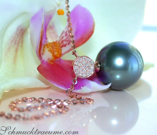 Tahitiperlen-Anhänger mit Diamanten in Roségold, umgeben von Orchideenblüten. Tahitiperlen-Anhänger mit Diamanten in Roségold, umgeben von Orchideenblüten.