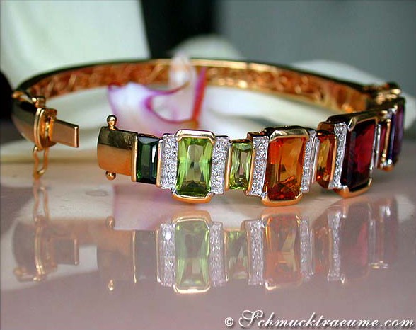 Goldener Multicolor-Armreif mit Edelsteinen und Diamanten, detailreich, elegant.