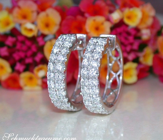 Weißgold Creolen mit Diamanten, Blumen im Hintergrund, Detailaufnahme Weißgold Creolen mit Diamanten, Blumen im Hintergrund, Detailaufnahme