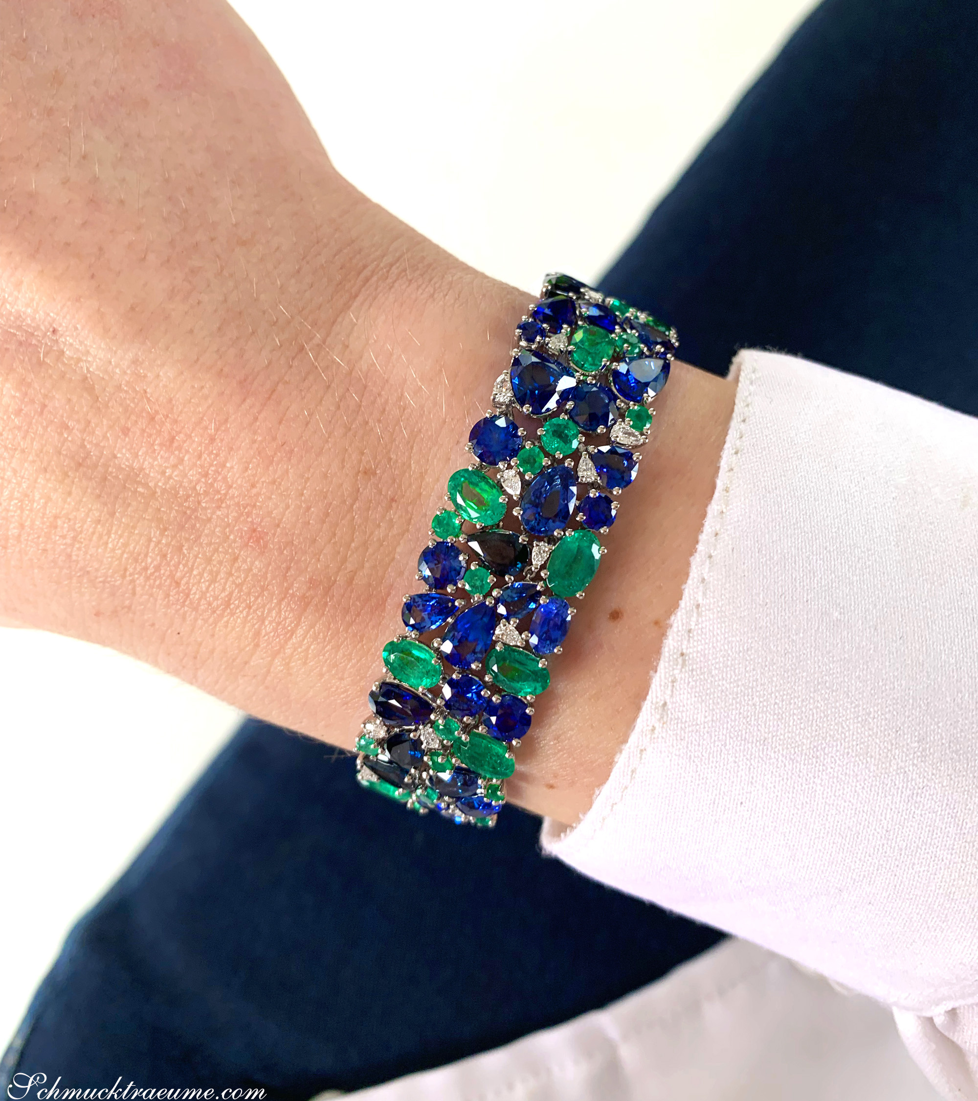 Luxuriöses Saphir-Armband mit Smaragden und Diamanten auf Hand.