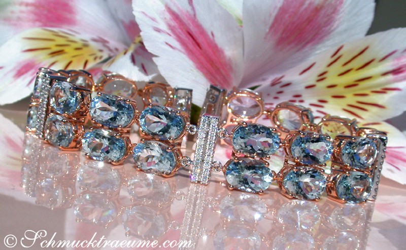 Goldene Aquamarin-Armband-Detailaufnahme mit Diamanten und Blütenhintergrund