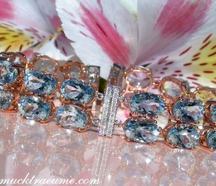 Goldene Aquamarin-Armband-Detailaufnahme mit Diamanten und Blütenhintergrund