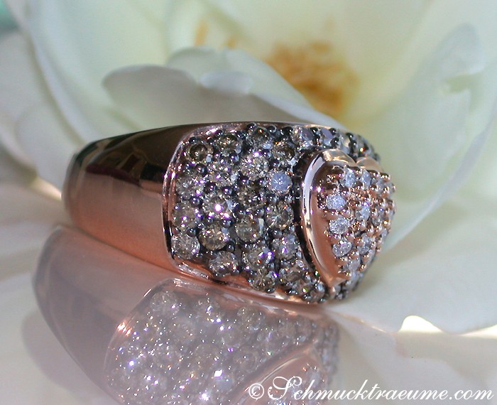 Detail des Herz-Rings mit braunen und weißen Brillanten, Roségold 585, auf weißer Blume liegend.