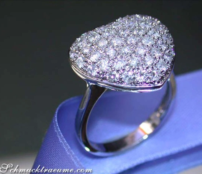 Diamant Herzring aus Weißgold, detailreiches Herz mit vielen Diamanten, elegant auf blauem Hintergrund. Diamant Herzring aus Weißgold, detailreiches Herz mit vielen Diamanten, elegant auf blauem Hintergrund.