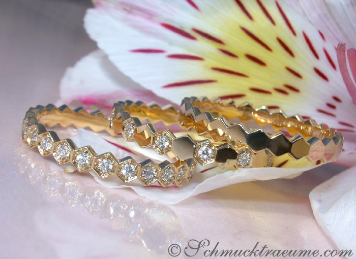 Goldene Diamantring-Set mit hexagonalen Details, auf Blütenblatt gelegt