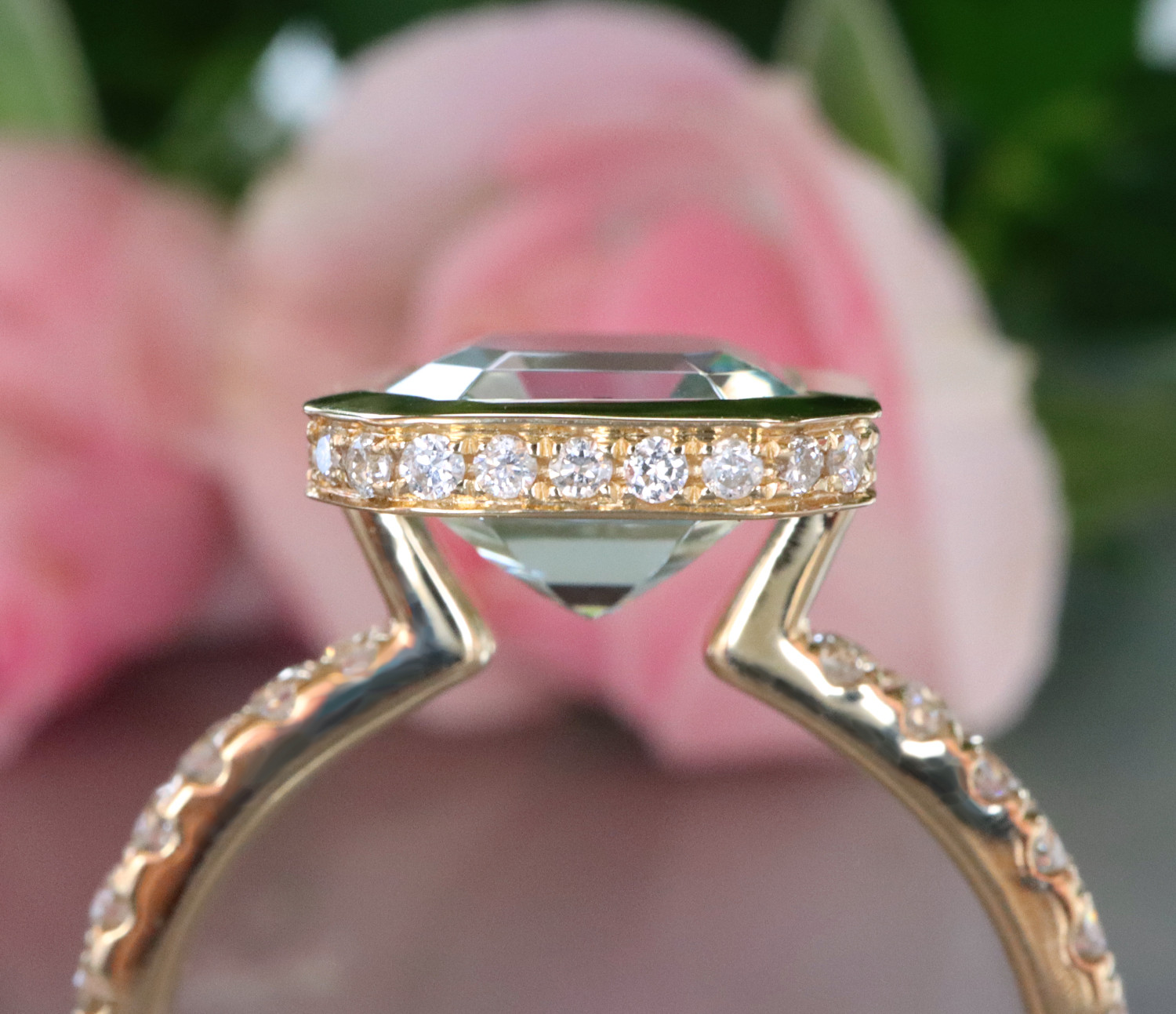 Goldener Aquamarin-Ring mit Brillanten vor rosa Blume