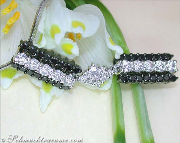 Detailansicht von Weißgold-Anhänger mit schwarzen und weißen Diamanten, Blume im Hintergrund.