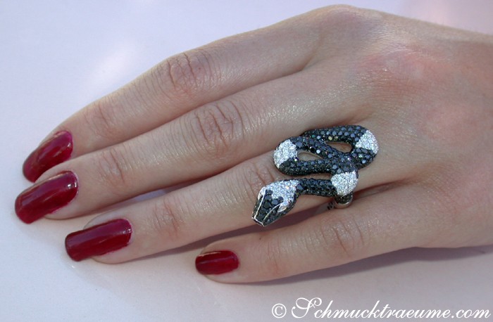Weißgold-Ring mit schwarzen Diamanten im Schlangen-Design getragen.