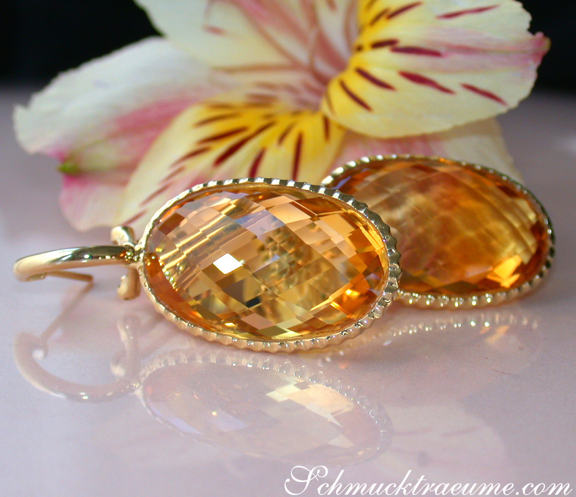Goldene Citrin-Ohrhänger mit klaren Linien, detailreich, vor Blüte gestellt