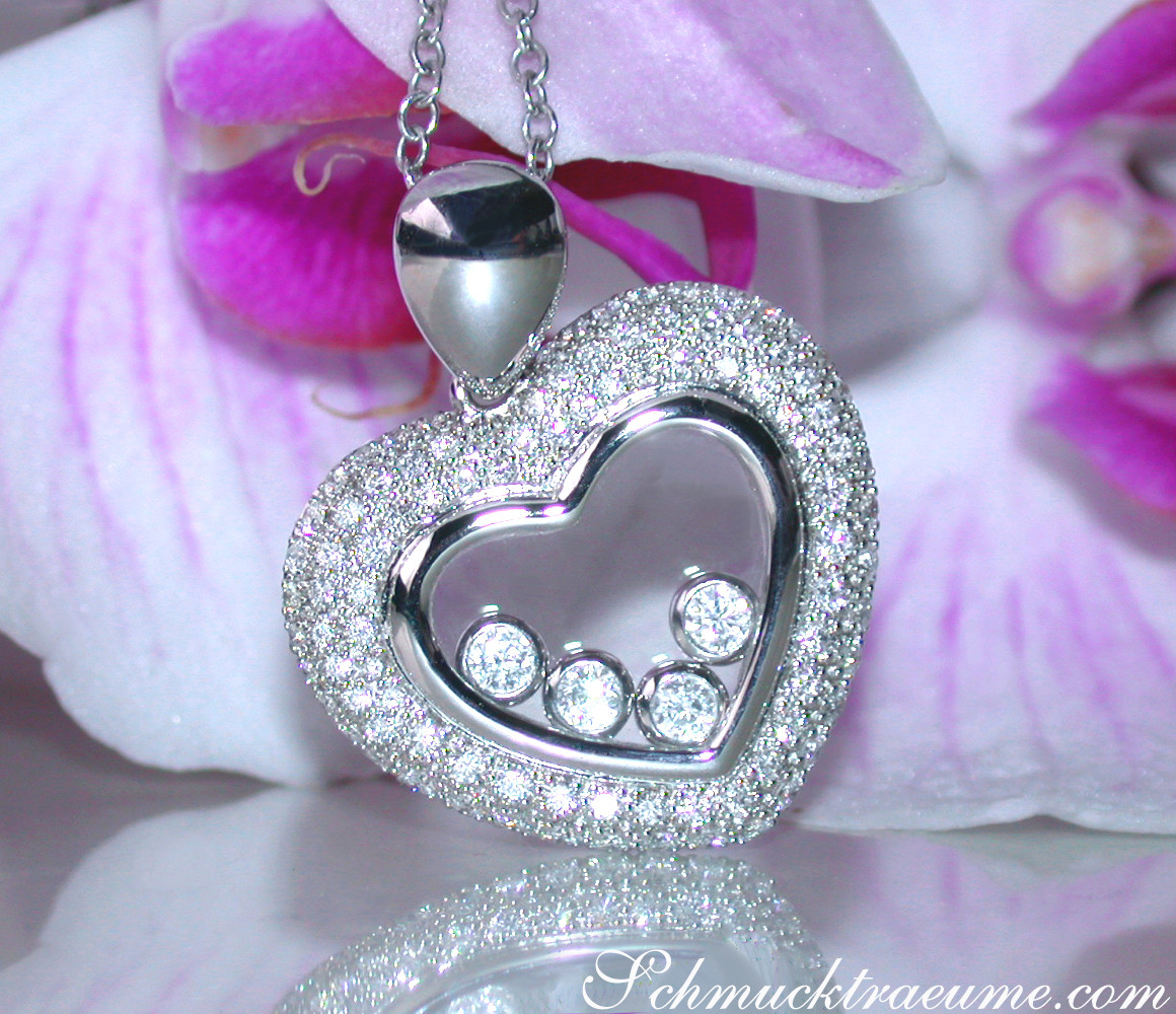 Herz-Anhänger mit Brillanten und Diamanten, detailreich, vor Orchideenblüten.