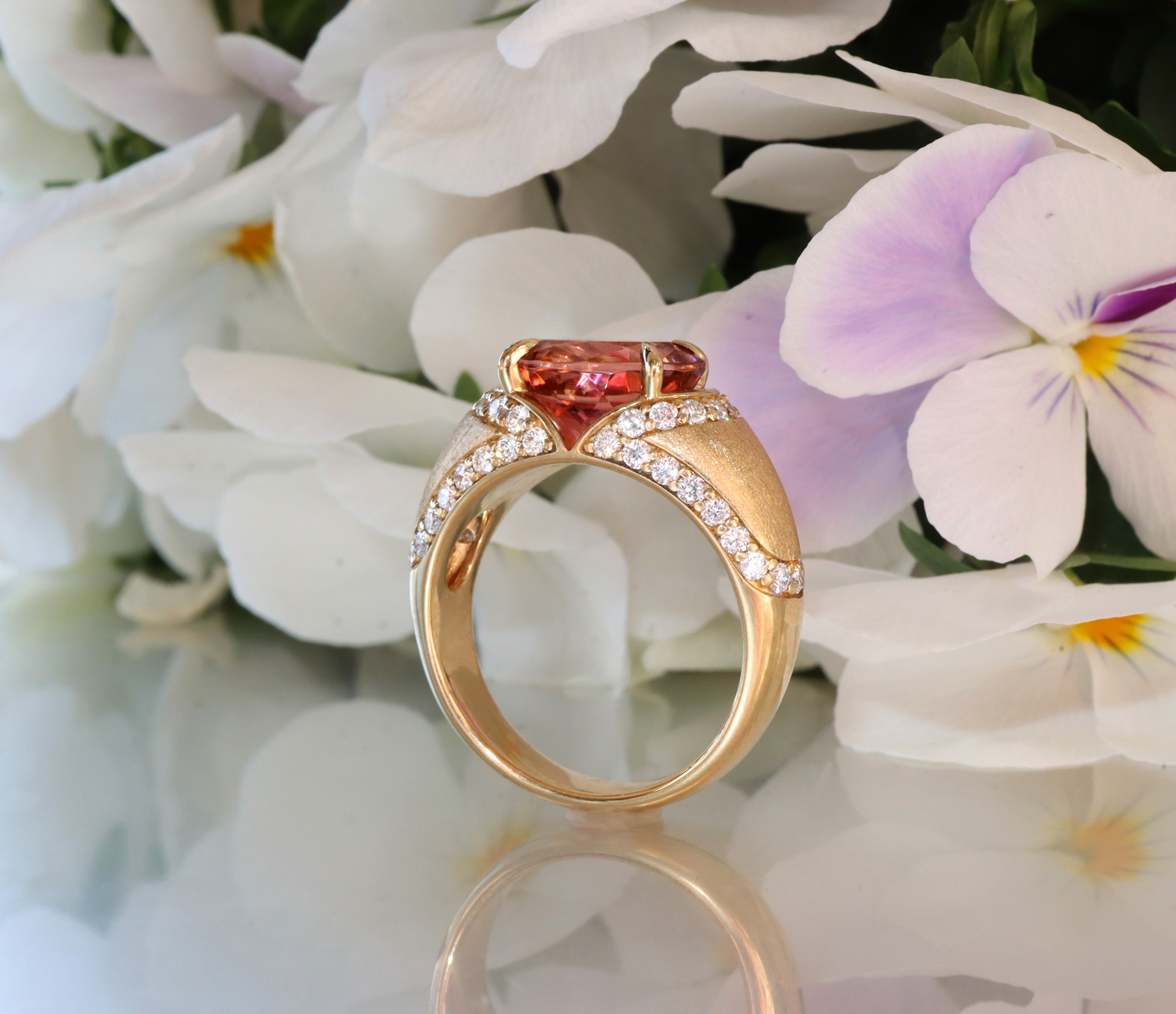 Goldener Turmalin-Ring mit Diamanten, Detailaufnahme, auf Blütenblättern liegend