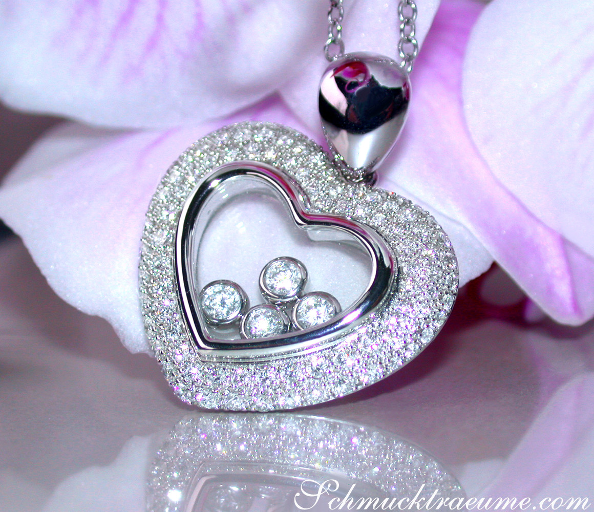 Herz-Anhänger mit Brillanten und Diamanten, glänzendes Herz auf Kette, vor Blüte.