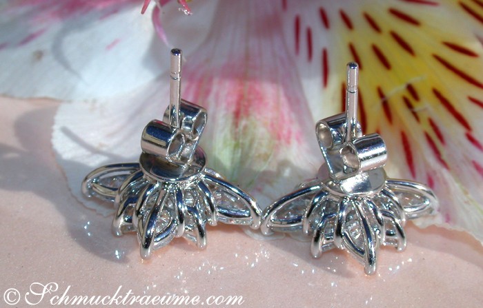 Silberne Ohrstecker mit Diamanten in Sternform auf Muschelhintergrund