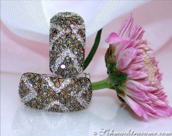 Detailansicht von Halb Creolen mit braunen Diamanten auf weißem Stoff, begleitet von Blume