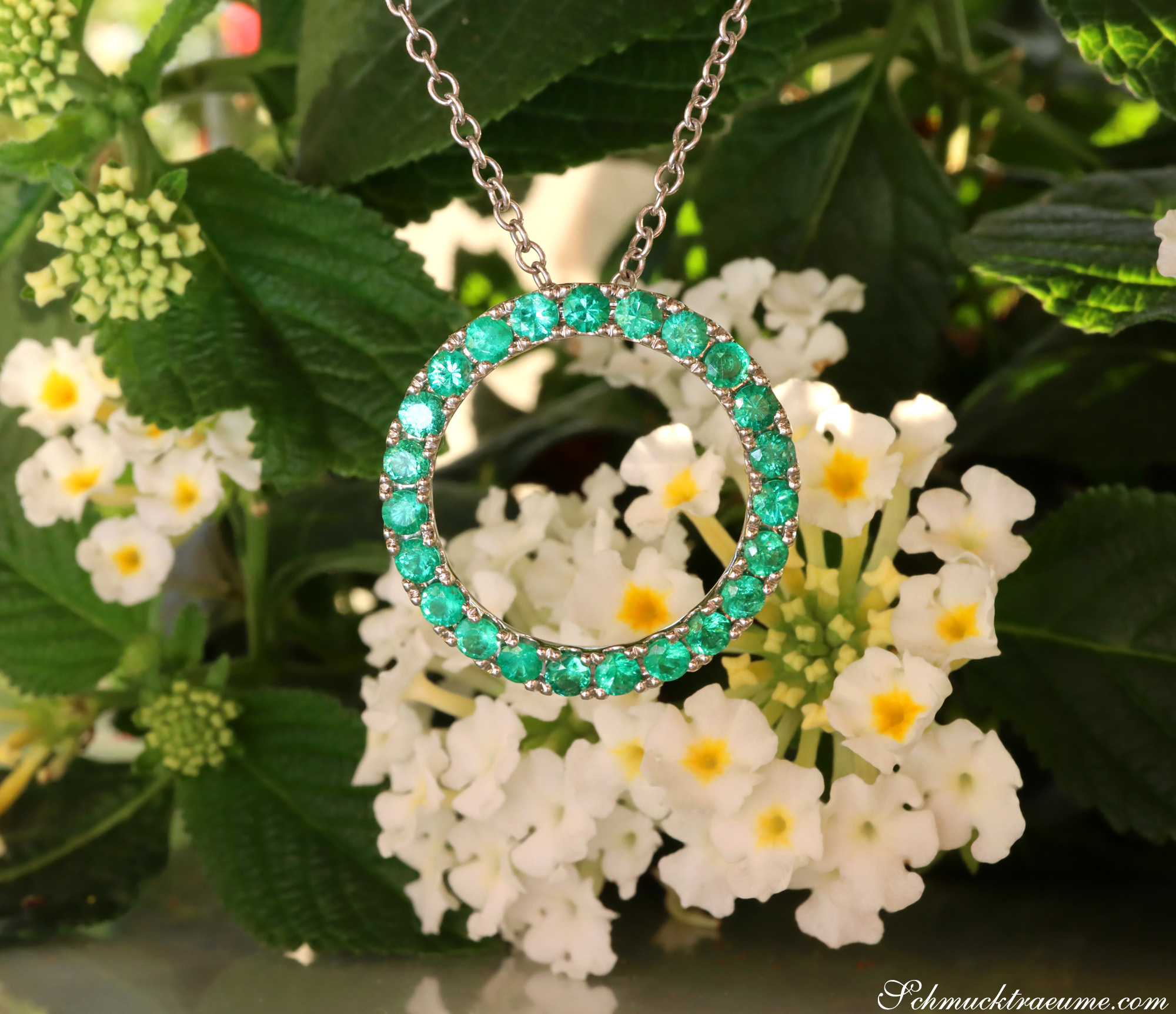 Smaragd-Kreis-Anhänger aus Weißgold 750, Detailaufnahme mit feinen Smaragden, umgeben von weißen Blüten.