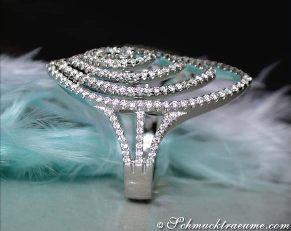 Schmuckstück mit spiralförmigem Diamantbesatz auf Federhintergrund