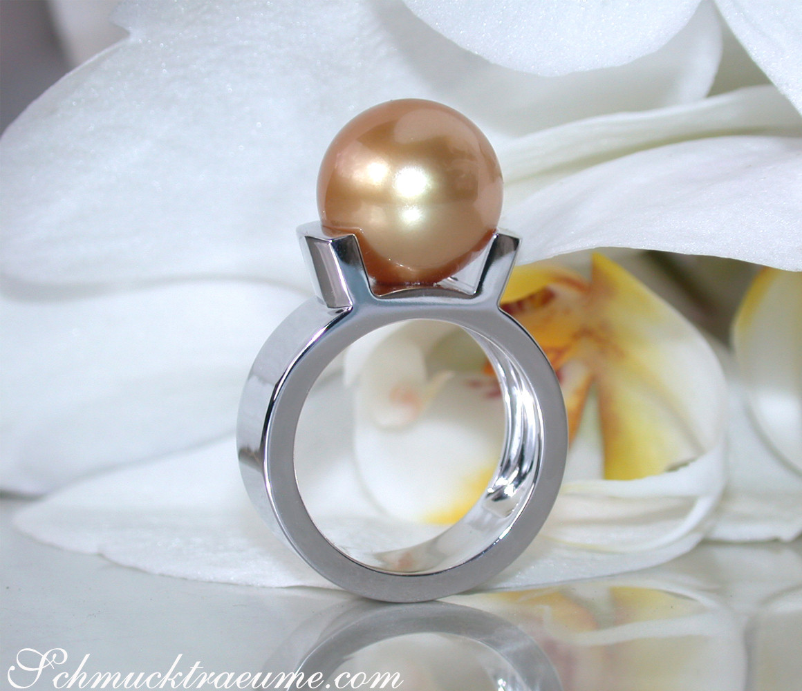 Goldener Südseeperlenring auf weißem Blütenblatt, Detailaufnahme