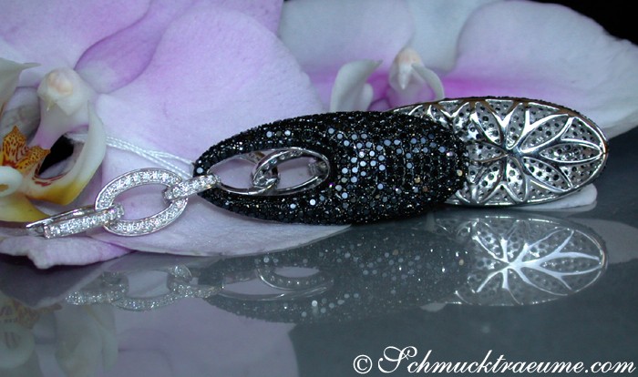 Schwarze Diamanten Ohrgehänge in Weißgold, Detailaufnahme, lang, glitzernd, auf Blüte liegend