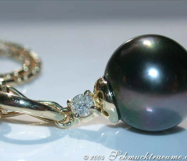 Gelbgoldanhänger mit 10-11 mm Tahitiperle und Diamant, Detailansicht, glänzender Perlenknoten. Gelbgoldanhänger mit 10-11 mm Tahitiperle und Diamant, Detailansicht, glänzender Perlenknoten.