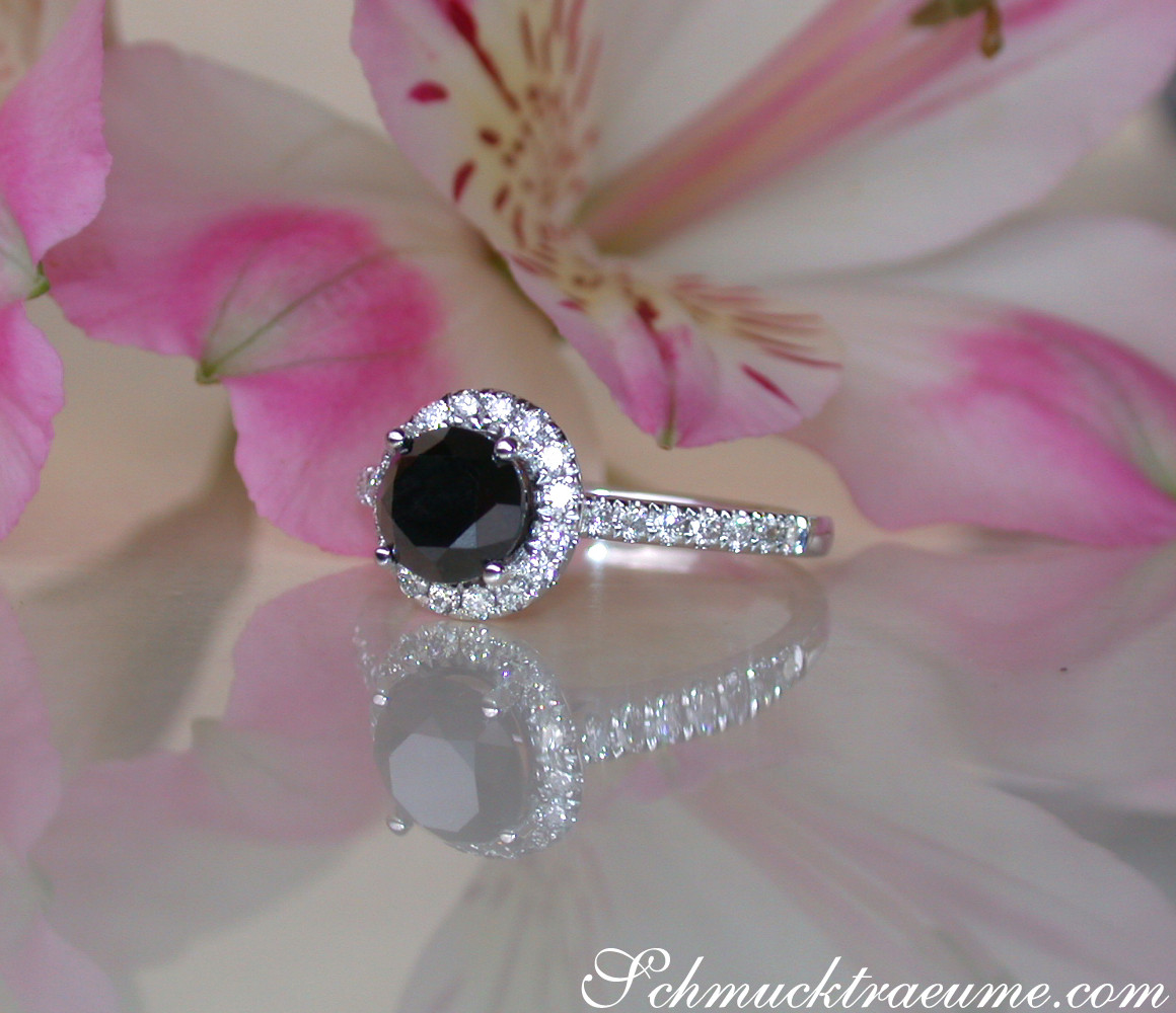 Schwarz-diamantiger Solitär-Ring mit Diamant-Halo auf Blütenblatt.