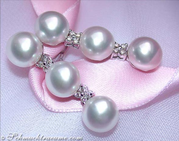 Perlenohrringe mit Diamanten auf rosa Satinband