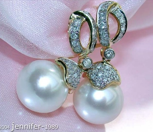 Gelbgold-Ohrringe mit Perlen und Brillanten, elegant auf rosa Stoff platziert.