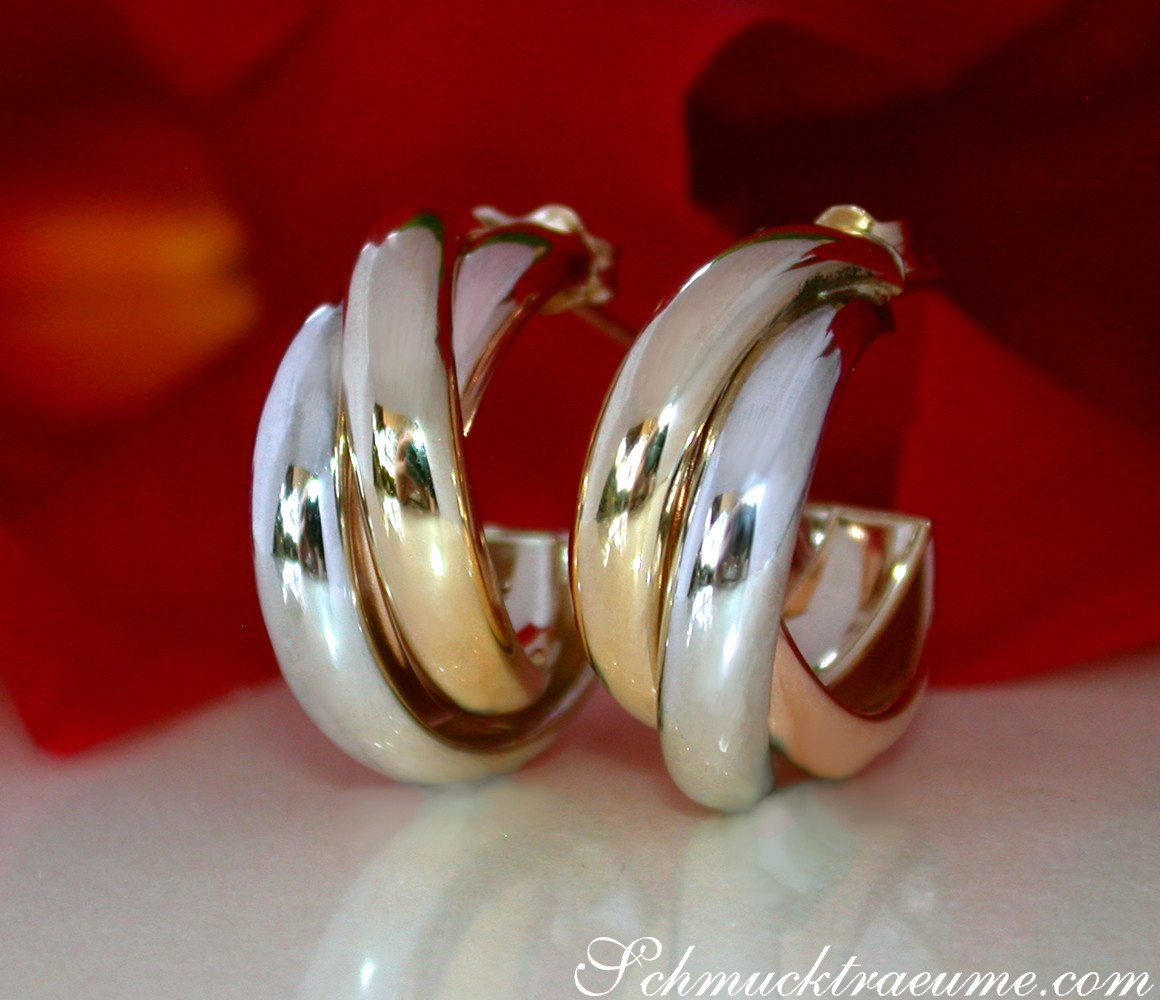 Gold Creolen "Tricolor" in Gelb-, Rosé- und Weißgold 585 auf rotem Hintergrund.