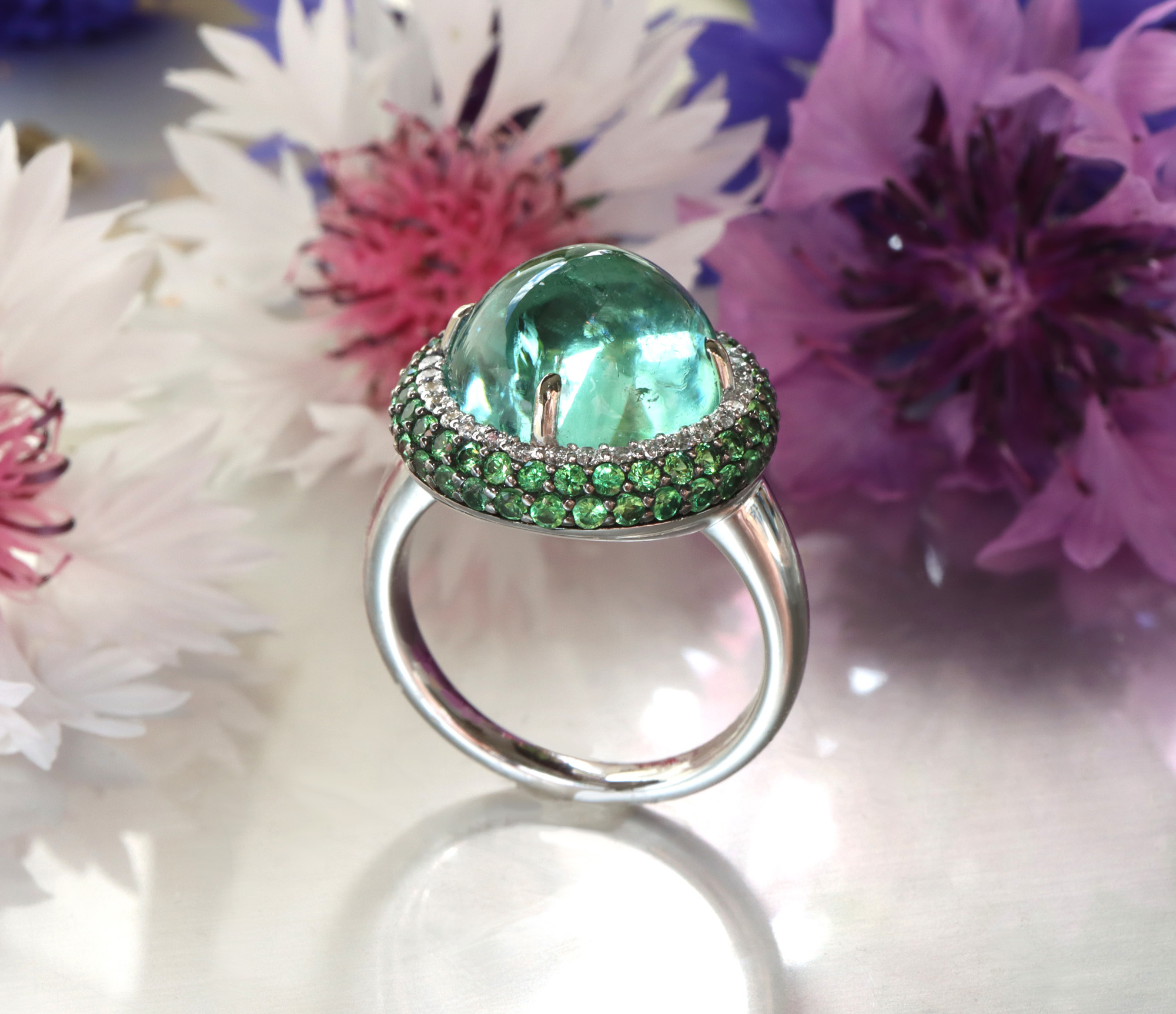 Minz-Turmalin-Ring mit Tsavorite und Brillanten, detailreich, auf Blütenhintergrund, Ringdetail, Weißgold 750