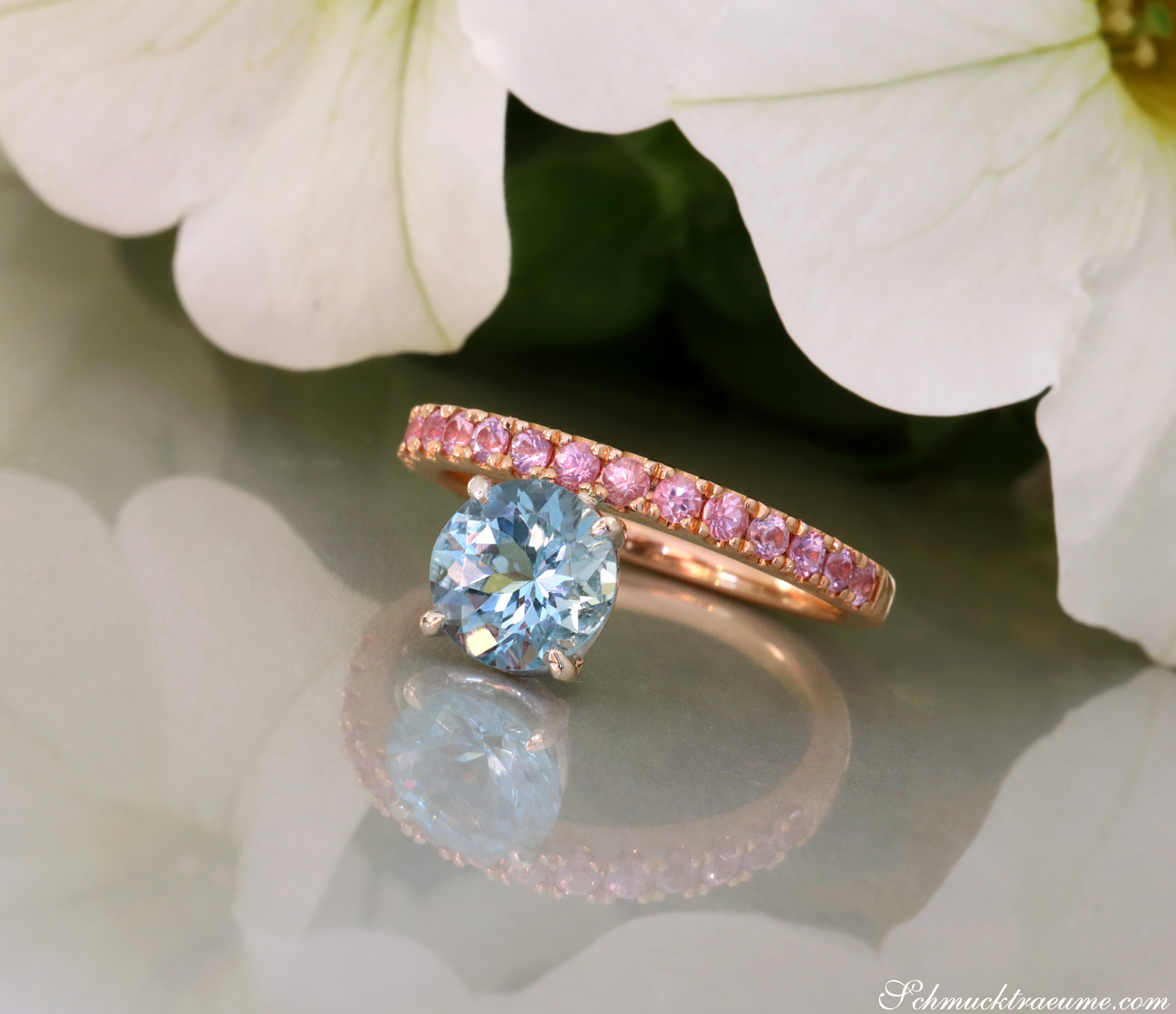 Raffinierter Aquamarin-Ring mit rosa Saphiren, Roségold, Detailaufnahme, Blume im Hintergrund