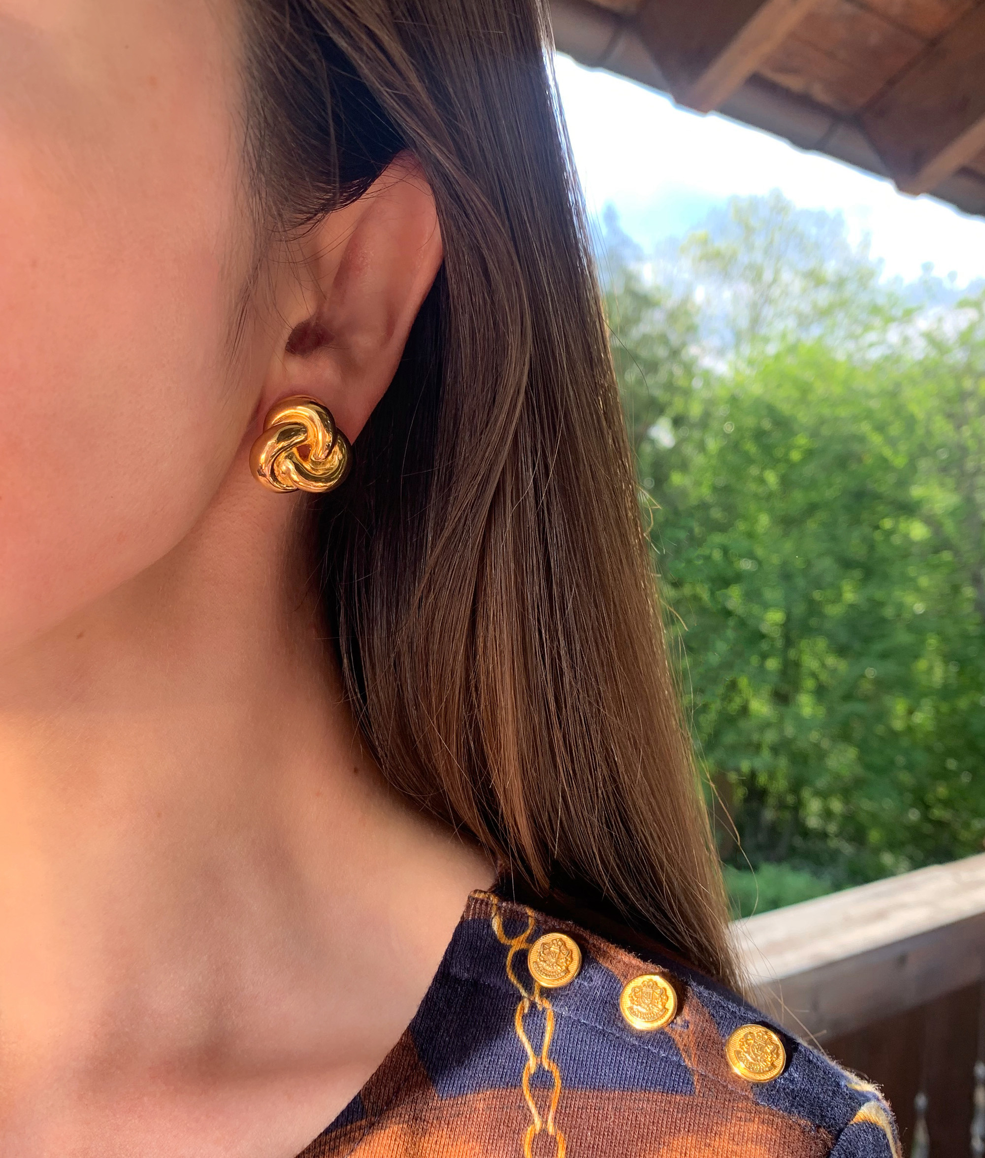 Goldener Knoten Ohrstecker aus 585er Gelbgold, Detailaufnahme an träger Schulter