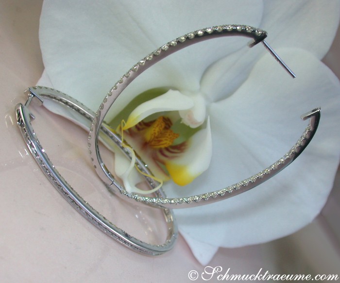 Ovale Brillanten Creolen aus Weißgold 750, Detailaufnahme mit Orchidee im Hintergrund