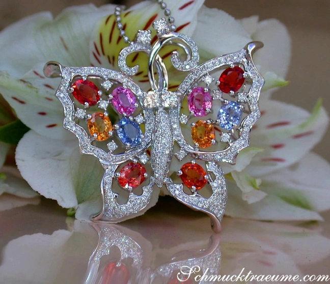 Weißgold Schmetterling-Anhänger mit Regenbogen-Saphiren und Brillanten, auf Blüte präsentiert. Weißgold Schmetterling-Anhänger mit Regenbogen-Saphiren und Brillanten, auf Blüte präsentiert.
