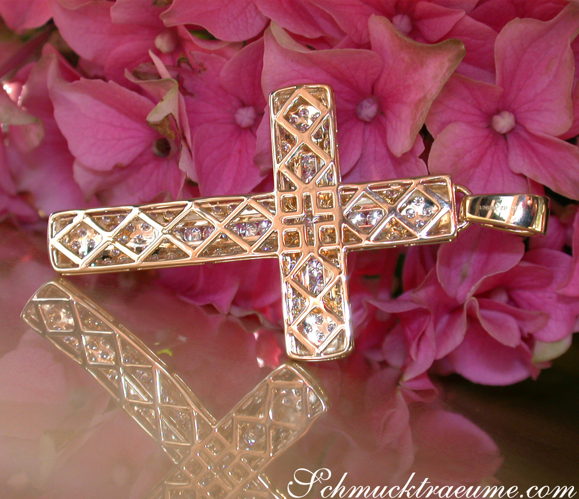 Gelbgold 750 Kreuzanhänger mit Brillanten, Detailaufnahme, rosa Blüten im Hintergrund