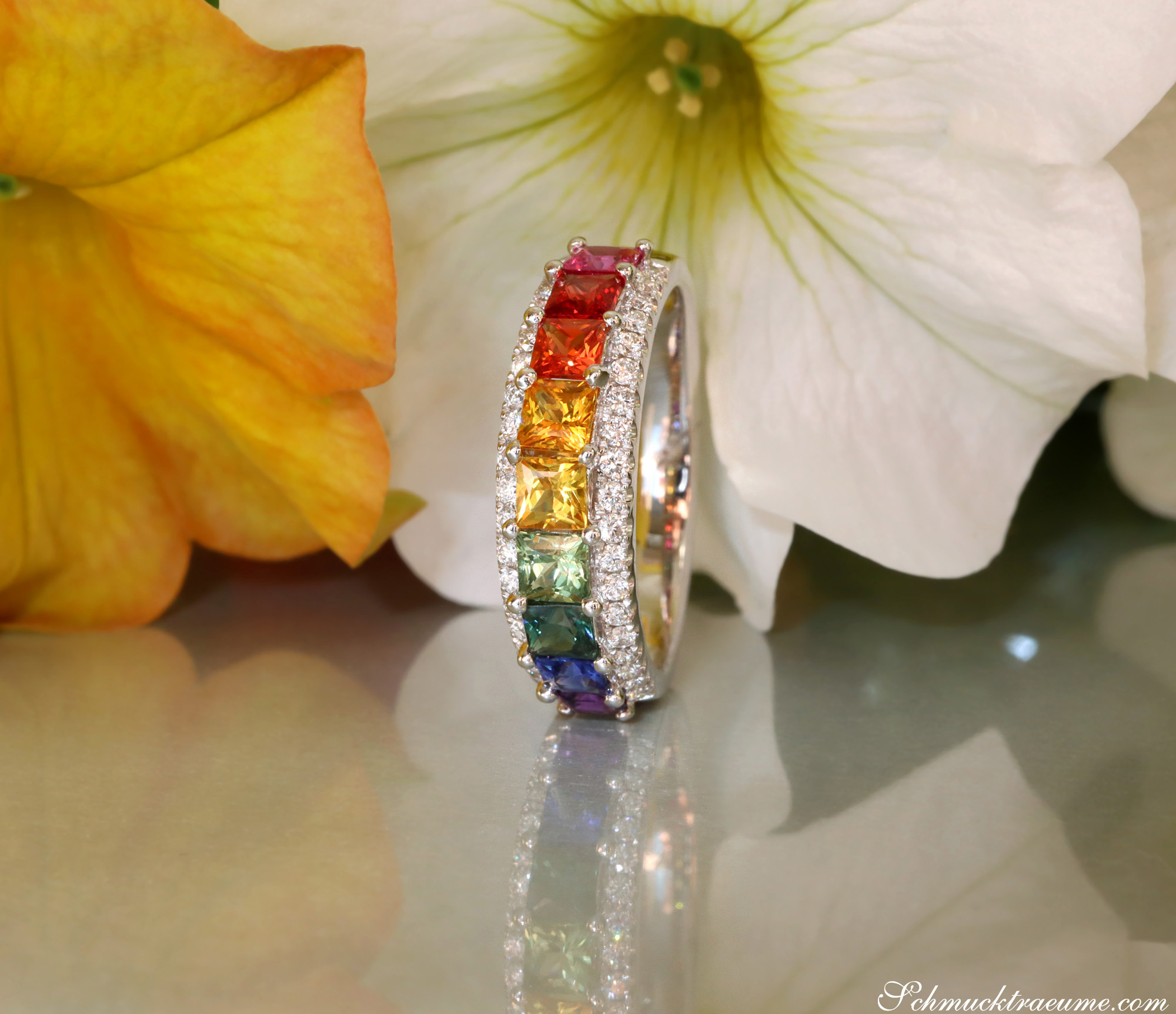 Regenbogen-Saphir-Ring mit Brillanten auf Blütenhintergrund