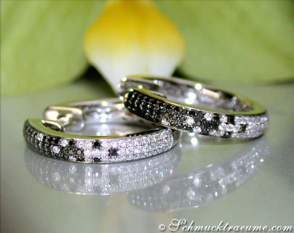 Schwarze Diamant-Creolen mit weißem Gold, Detailaufnahme, elegant auf glänzender Oberfläche