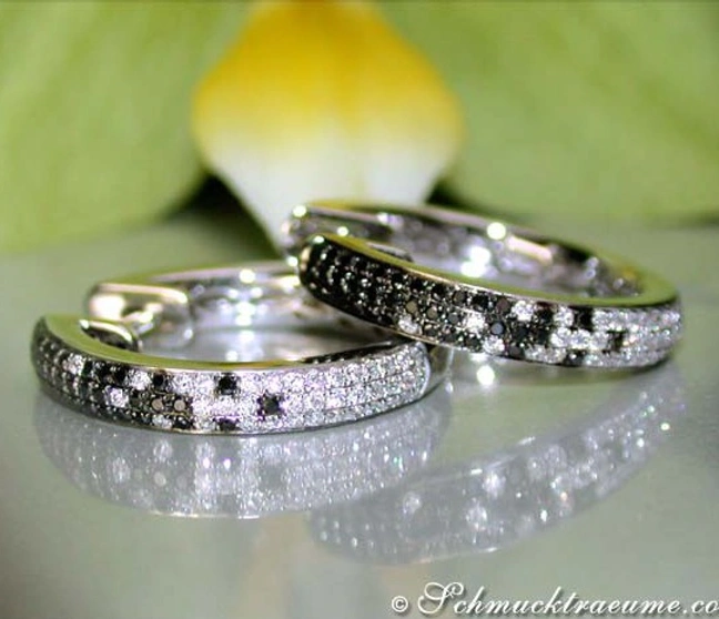 Schwarze Diamant-Creolen mit weißem Gold, Detailaufnahme, elegant auf glänzender Oberfläche Schwarze Diamant-Creolen mit weißem Gold, Detailaufnahme, elegant auf glänzender Oberfläche