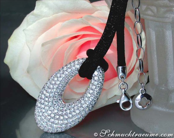 Opulenter Diamant-Donut-Anhänger auf Satinkordel vor Rosenblüte