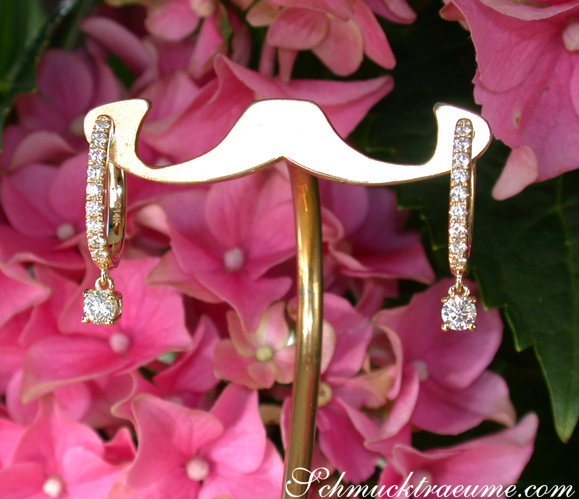 Goldene Creolen mit Swinging Diamonds in Gelbgold 585/000, detailliertes Blumenhintergrund.