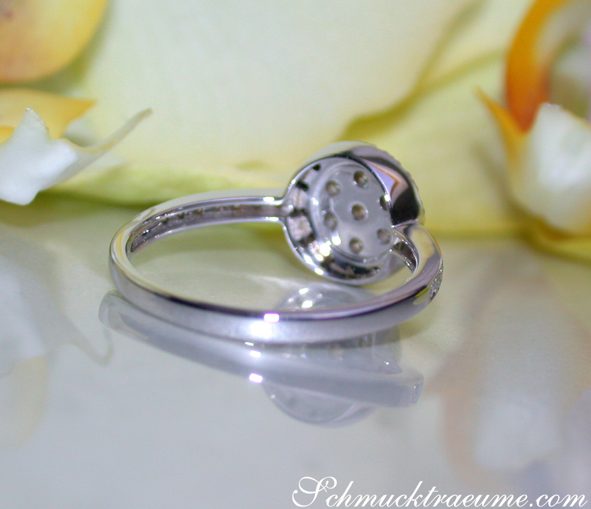 Schwarz/weiß Diamanten-Ring auf glänzender Oberfläche, Detailaufnahme mit reflektierendem Hintergrund.